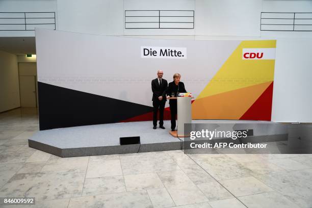 German Chancellor Angela Merkel stands next to CDU secretary general Peter Tauber as she gives a statement on September 12, 2017 in Berlin to express...