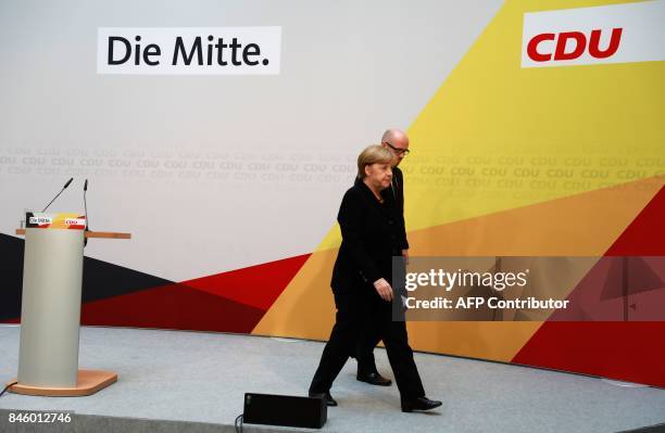 German Chancellor Angela Merkel is accompanied by CDU secretary general Peter Tauber as she leaves after giving a statement on September 12, 2017 in...