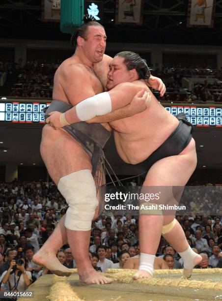 Mongolian ozeki Terunofuji pushes Georgian wrestler Tochinoshin out of the ring to win during day three of the Grand Sumo Autumn Tournament at...