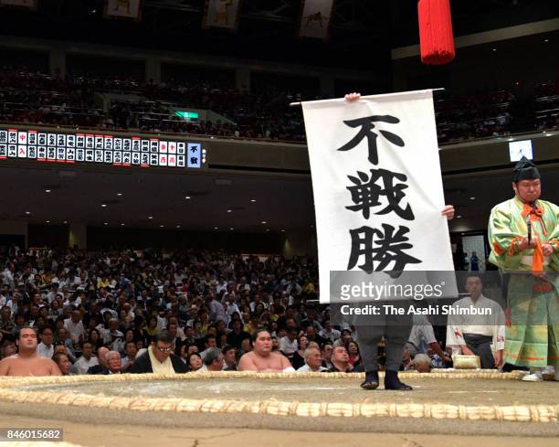 Staff holds a banner to announce Hokutofuji's win by default as ozeki Takayasu withdrew due to the injury during day three of the Grand Sumo Autumn...