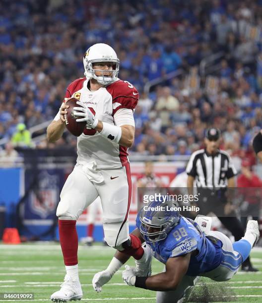 Carson Palmer of the Arizona Cardinals rolls out as Jeremiah Ledbetter of the Detroit Lions gives chase during the third quarter of the game against...