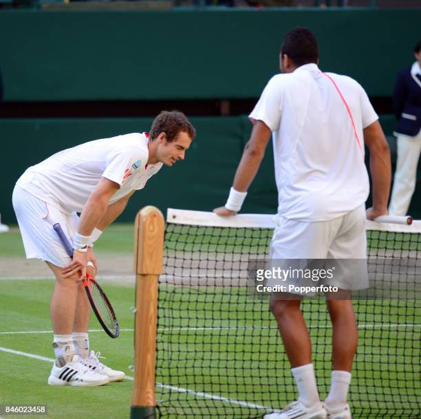Andy Murray of Great Britain and Jo-Wilfried Tsonga of France await the verdict of Hawkeye before victory is declared for Murray on Day Eleven of the...