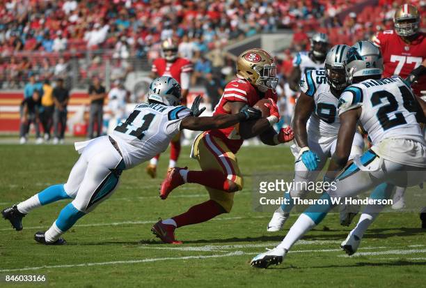 Carlos Hyde of the San Francisco 49ers carries the ball while pursued by Captain Munnerlyn of the Carolina Panthers during the second quarter of...