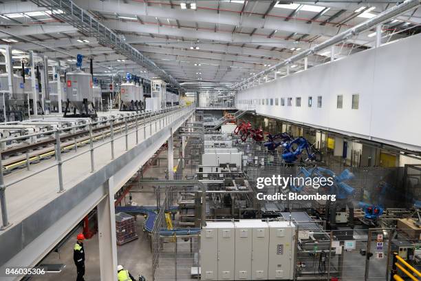 Automated robots for stacking pallets of paint stand at the end of the production line at Akzo Nobel NV's new paint factory in Ashington, U.K., on...