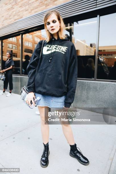 Model is seen after runway show wearing black hoodie and jeans skirt during New York Fashion Week on September 11, 2017 in New York City.