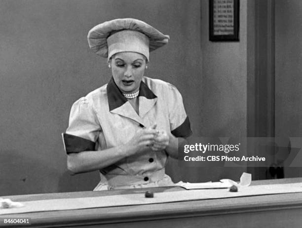 American comedienne and actress Lucille Ball , as Lucy Ricardo, works at a candy factory conveyor belt in an episode of the television comedy 'I Love...