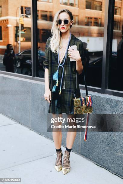 Guest is seen wearing gold sunglasses, green and blue dress, gold shoes during New York Fashion Week on September 11, 2017 in New York City.