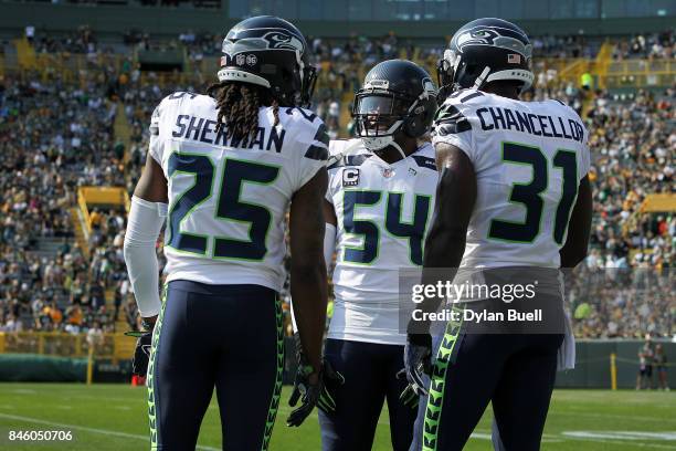 Richard Sherman, Bobby Wagner and Kam Chancellor of the Seattle Seahawks meet before the game against the Green Bay Packers at Lambeau Field on...