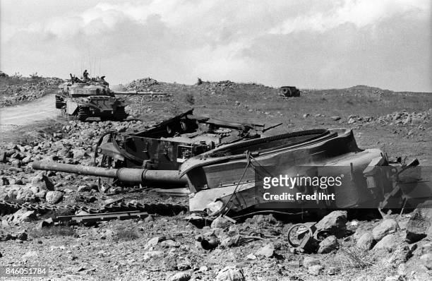 Destroyed tank in the foreground. Soldiers in working tanks in the background during the Yom Kippur war.