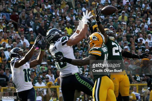 Morgan Burnett and Quinten Rollins of the Green Bay Packers break up a pass in front of Tyler Lockett and Jimmy Graham of the Seattle Seahawks in the...