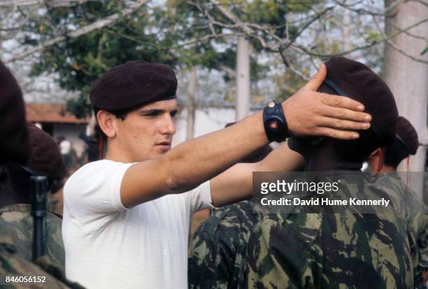 Colonial Portuguese soldier adjust a cadet's beret at an inspection, during the Mozambican War of Independence, Ancuabe, Cabo Delgado Province,...