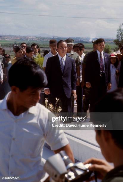 Republic of Vietnam President Nguyen Van Thieu stands, with others, at a grave in the National Military Cemetery, Thu Duc, South Vietnam, 1973.