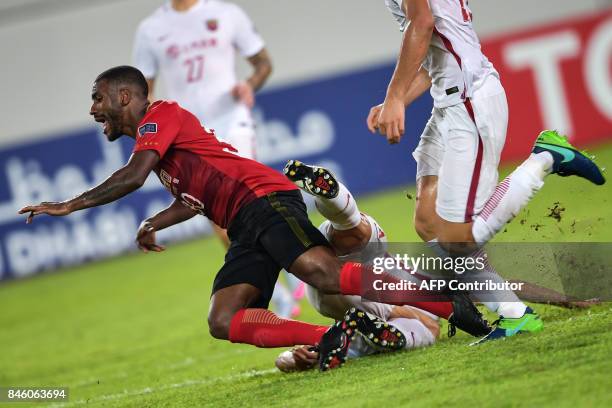 Guangzhou Evergrande's Muriqui falls as he fights for the ball during their AFC Champions League quarter-final football match against Shanghai SIPG...