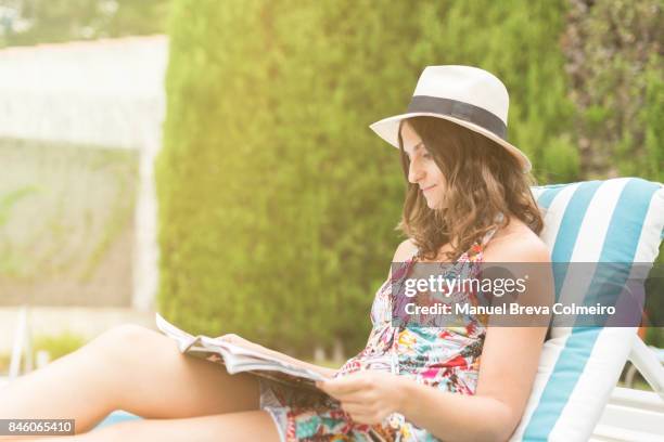 young woman reading a magazine - women swimming pool retro bildbanksfoton och bilder