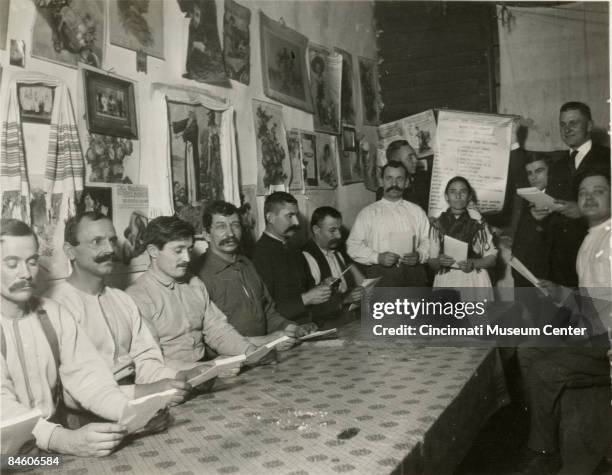 In Winton Place, a factory district, a teacher conducts a class teaching recent immigrants the English language, Cincinnati, Ohio, 1914.