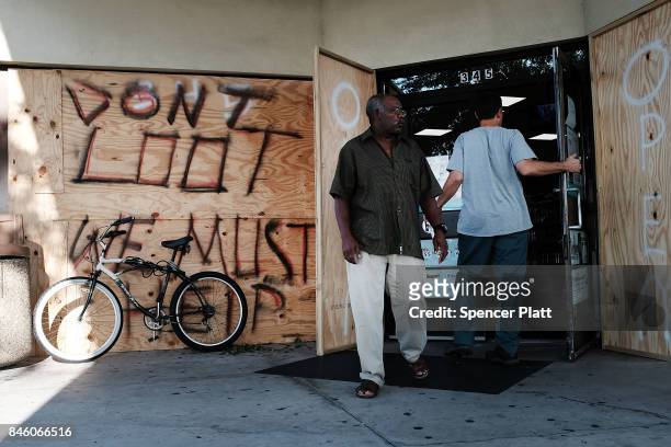 Man exits a 7-Eleven, one of the few stores open two days after Hurricane Irma swept through the area on September 12, 2017 in Cape Coral, Florida....