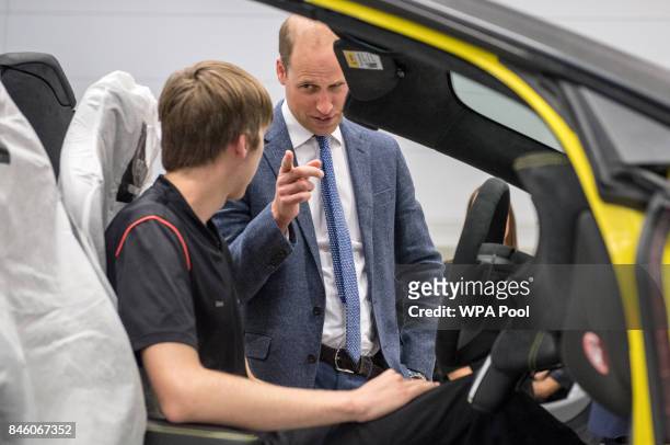Prince William, Duke of Cambridge helps fit an airbag to a McLaren car with apprentice of the year nominee Alex Machin on the factory floor during a...