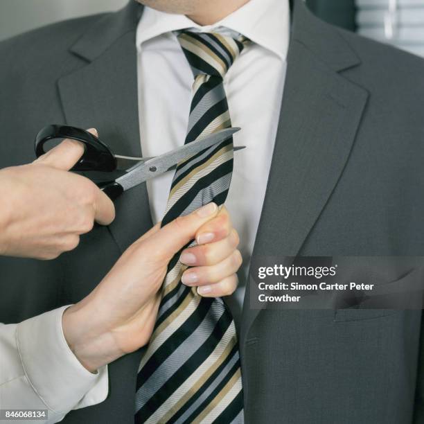 woman cutting businessman's tie. - avengers stock pictures, royalty-free photos & images