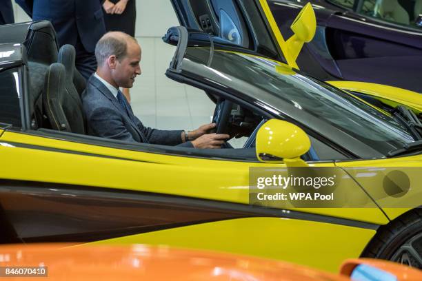 Prince William, Duke of Cambridge starts the engine of a finished McLaren on the factory floor during a visit to McLaren Automotive at McLaren...