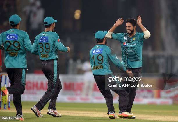 Pakistani bowler Rumman Raees celebrates with teammates after taking the wicket of World XI batsman Tamim Iqbal during the first Twenty20...