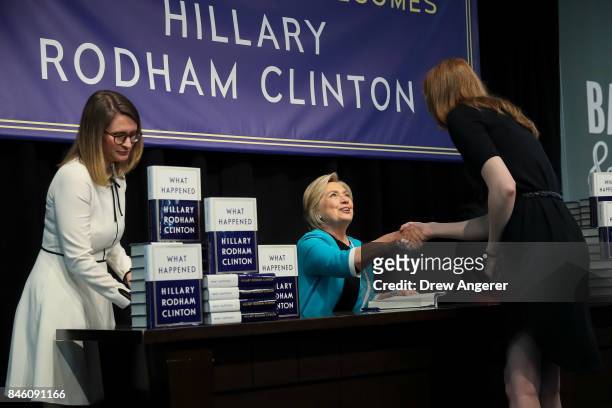Former U.S. Secretary of State Hillary Clinton signs copies of her new book "What Happened" during a book signing event at Barnes and Noble...
