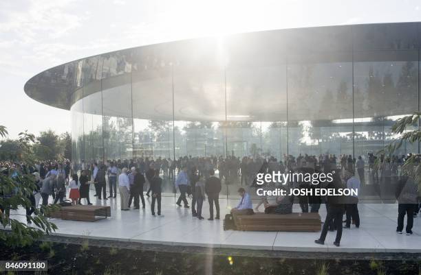 People gather at Apple's new headquarters ahead of a media event where Apple is expected to announce a new iPhone and other products in Cupertino,...