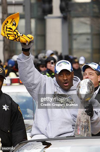 James Harrison of the Pittsburgh Steelers waves a Terrible Towel while holding the Super Bowl XLIII trophy during a parade on February 3, 2009 in...