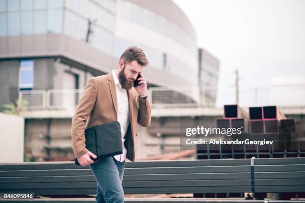 hipster businessman with laptop bag talking on mobile phone at the store warehouse - laptop bag stock pictures, royalty-free photos & images