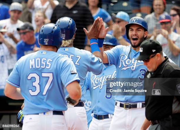 Eric Hosmer of the Kansas City Royals congratulates Salvador Perez and Brandon Moss as they cross the plate to score after Moss hit a grand slam home...