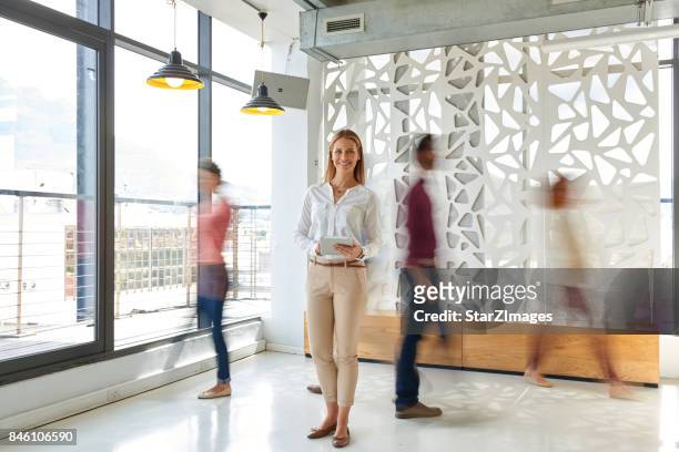 business woman standing out of the croud - bustling office stock pictures, royalty-free photos & images