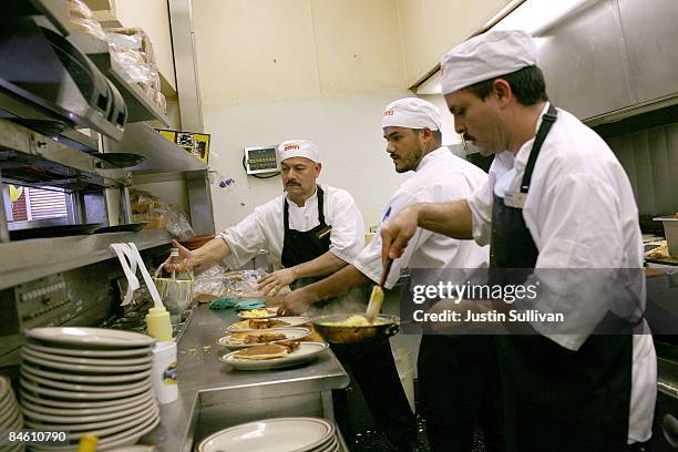 Denny's cooks prepare free Grand Slam breakfast plates February 3, 2009 in Emeryville, California. People lined up at Denny's across North America...