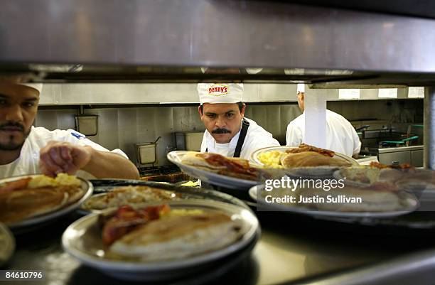 Denny's cooks prepare free Grand Slam breakfast plates February 3, 2009 in Emeryville, California. People lined up at Denny's across North America...