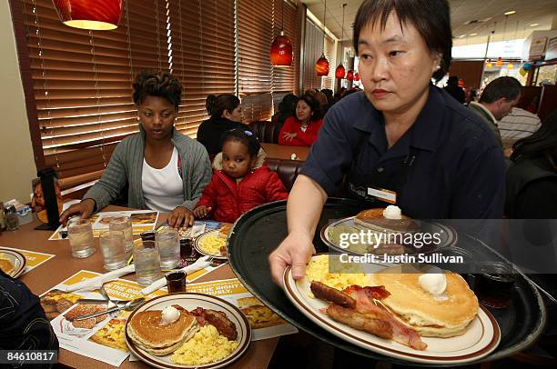 Denny's waitress Fong Van Luben delivers free Grand Slam breakfasts to customers February 3, 2009 in Emeryville, California. People lined up at...