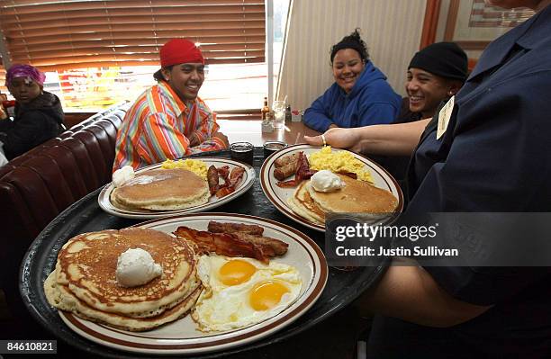 Denny's waitress Tahmina Najemyar delivers free Grand Slam breakfasts to customers February 3, 2009 in Emeryville, California. People lined up at...