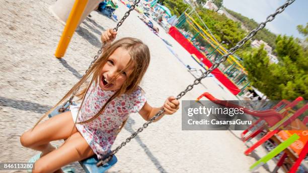 6 jahre alte fröhliche mädchen auf strandurlaub mit schaukel auf dem spielplatz - 6 7 years screaming girl stock-fotos und bilder