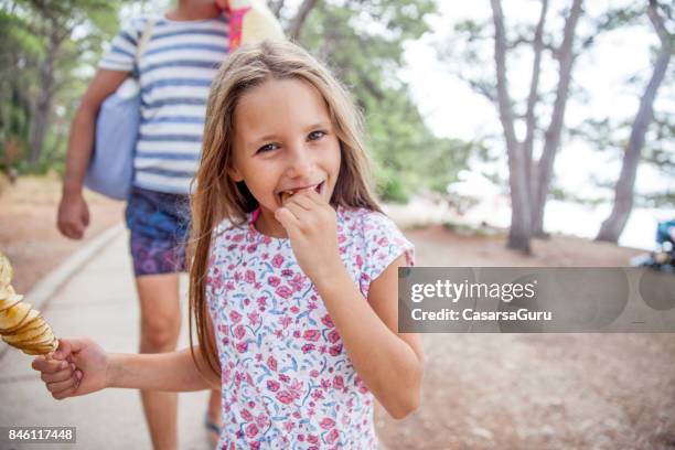 6 years old girl on a summer holiday enjoy eating fried potato slices on stick - family eating potato chips stock pictures, royalty-free photos & images