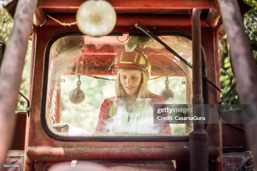 トラクターを運転して若い木こり女性