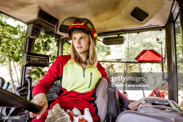 junge holzfäller frau einen traktor zu fahren - forestry worker stock-fotos und bilder