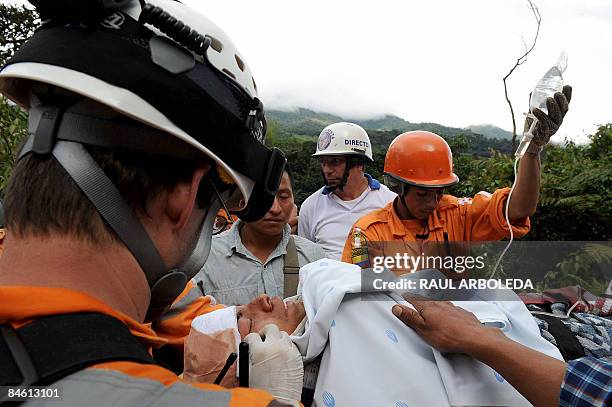 Rescue workers attempt to aid an unidentified man who was injured after a bus traveling from Medellin, Antioquia department, to Quibdo, Choco...