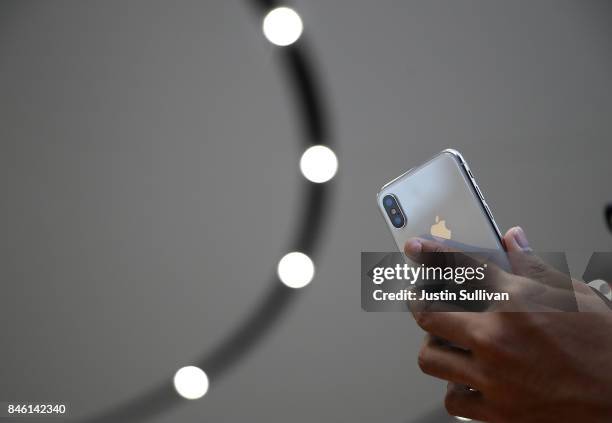 An attendee looks at a new iPhone X during an Apple special event at the Steve Jobs Theatre on the Apple Park campus on September 12, 2017 in...