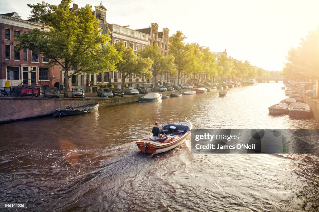 Boat on a canal in Amsterdam at sunset, Netherlands