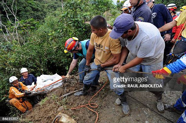 Rescue workers attempt to move the corpse of a victim who died after a bus traveling from Medellin, Antioquia department, to Quibdo, Choco...