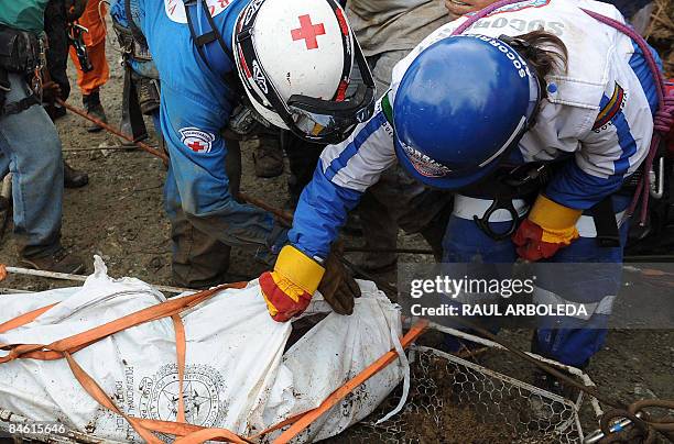 Rescue workers inspect the corpse of a victim who died after a bus traveling from Medellin, Antioquia department, to Quibdo, Choco department,...