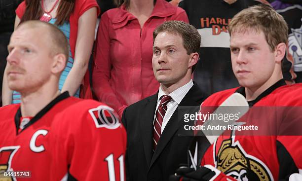 Cory Clouston of the Ottawa Senators looks on from behind the bench during the singing of the national anthems in his first career NHL game as head...