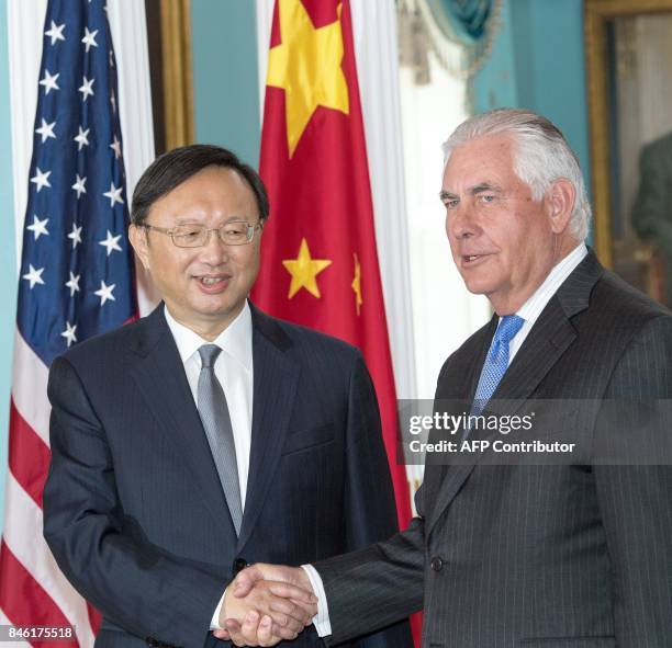 Secretary of State Rex Tillerson and Chinese State Councilor Yang Jiechi shake hands before their private meeting at the US Department of State...