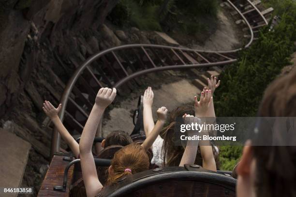 Visitors ride a roller coaster at the Walt Disney Co. Magic Kingdom park in Orlando, Florida, U.S., on Tuesday, Sept. 12, 2017. The Walt Disney Co....