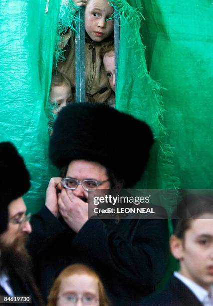 Young ultra-Orthodox Jewish girls peek through a partition to watch a religious Hasidic wedding celebration in the heart of Jerusalem on February 3,...