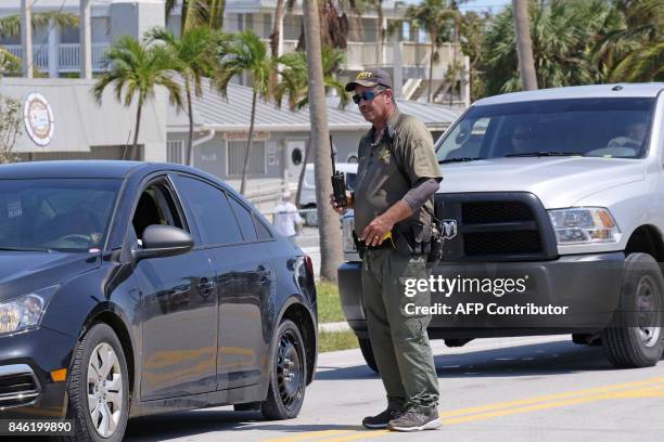 Monroe county deputy sheriff directs a Florida Keys, residents in the wake of hurricane Irma on September 12, 2017. Hurricane Irma weakened slightly...