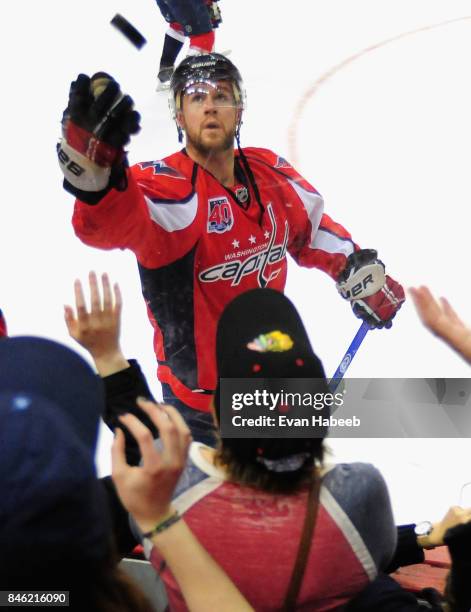 Mike Green of the Washington Capitals tosses a puck to the crowd before the game against the New Jersey Devils at Verizon Center on March 26, 2015 in...
