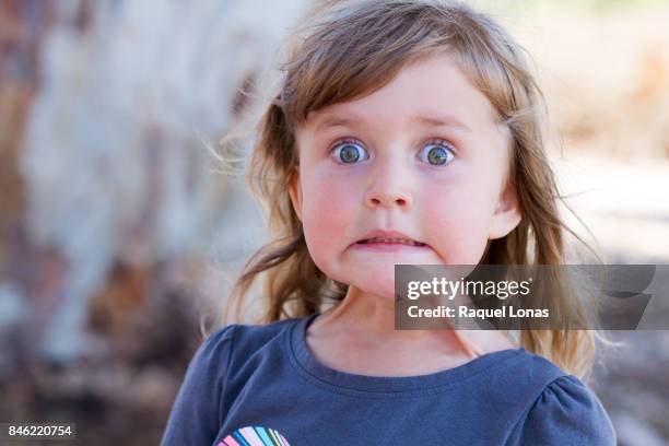 little girl making a face - child nervous stock-fotos und bilder